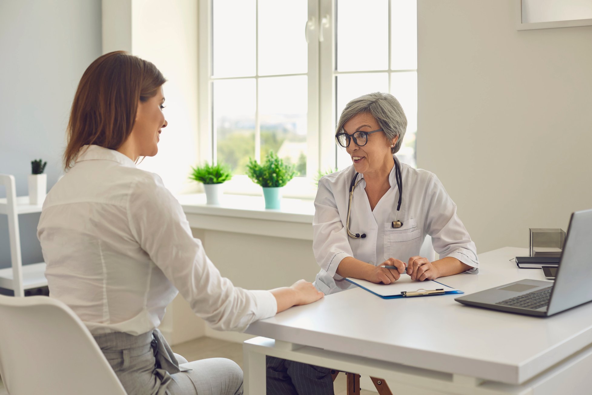 Senior Woman Doctor Therapist Consulting Woman Patient in Medical Clinic Office during Clinic